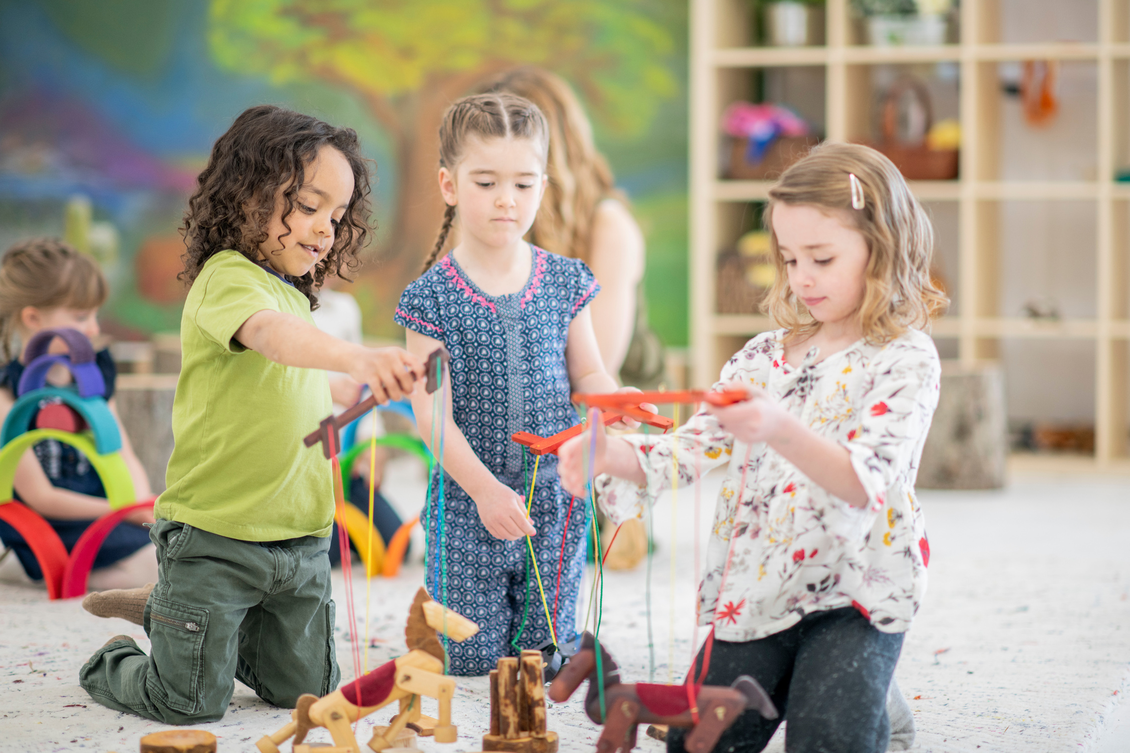 Waldorf elementary school children playing with wooden puppets in class